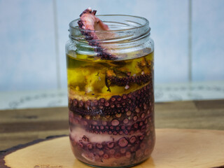 close up view of a marinated octopus with olive olio in the jar