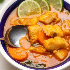 Fish soup with vegetables on white background. Mexican food