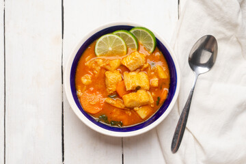 Fish soup with vegetables on white background. Mexican food