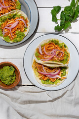 Chicken tinga tacos with guacamole and onion on white background. Mexican food