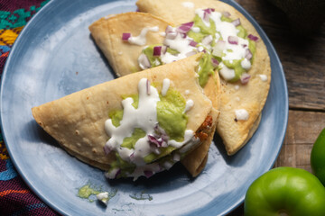 Fried tacos with guacamole and sour cream on wooden background. Mexican food