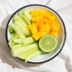 Cucumber and mango salad on white background