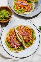 Chicken tinga tacos with guacamole and onion on white background. Mexican food