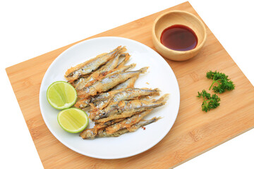 Grilled shishamo fish served with lemon and sweet sauce on wooden board background