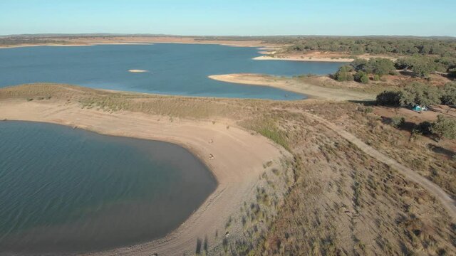 Aerial view of an Ovidelas dam, lake, reservoir in a dry area. Evening in Alvito in the Alentejo countryside, Portugal. Drone rotation.