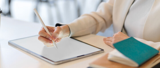 Cropped shot of businesswoman hand with stylus pen touching on mock tablet screen