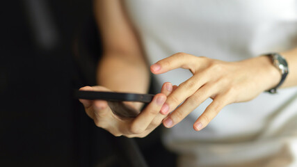 Female hand holding and finger touching on smartphone screen