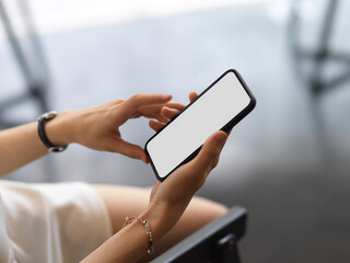 A woman using smartphone include clipping path screen in her hands