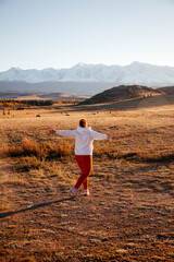 Happy young woman in Kurrai steppe in Altai Republic in early autumn