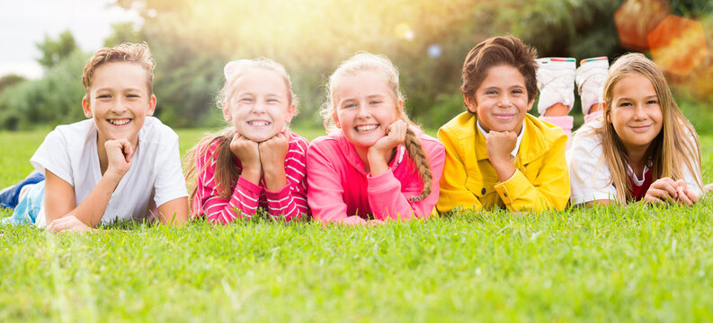 Portrait of children who are posing lying in the park.
