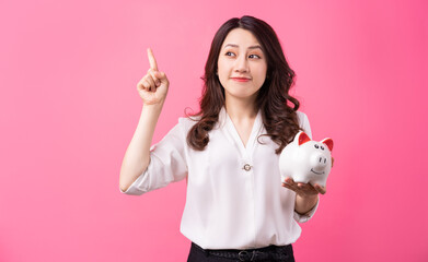 Asian businesswoman holding piggy in her hand, saving money concept