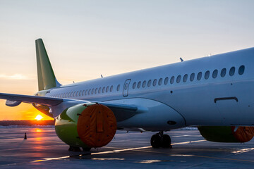Fototapeta na wymiar Close-up of the modern passenger airplane fuselage at sunset