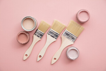 Overhead view of a DIY paint brush with pastel pink sample paint pots