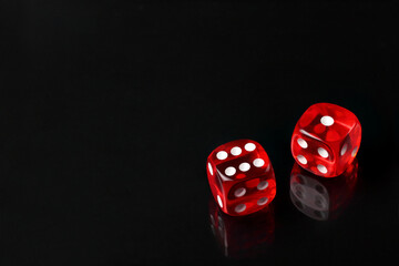 Red dice on black background with copy space. Top view.