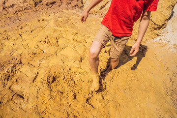 Unlucky person standing in natural quicksand river, clay sediments, sinking, drowning quick sand,...