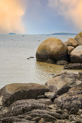Fototapeta na wymiar Crushed stones and huge rocks on the beach