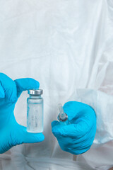 Fototapeta premium covid-19 sars-cov-2 vaccination: a health worker with a vaccine and a syringe in his hands