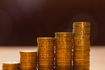 5 piles of coins on a table in a graphic disposition. Save money concept banner.
