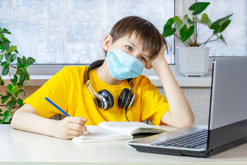 Little boy taking class online and using notebook for Homeschool Quarantine coranavirus pandemic...