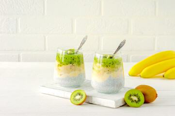 Chia seed pudding with kiwi, banana and mango. Health detox breakfast in glasses on white background