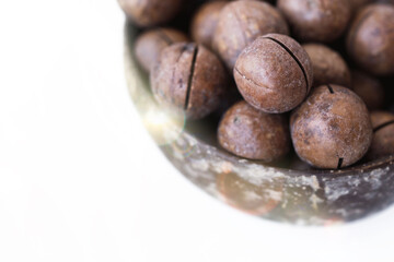 Macadamia nuts close up. Macadamia in shell in a brown plate