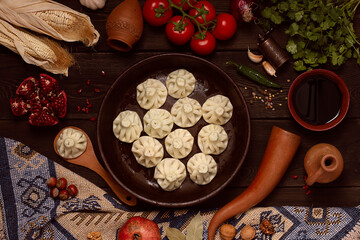Traditional Georgian dish, khinkali Qalaquri, with national clay dishes, rustic, top view, no people,