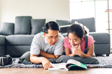 School kid little girl learning and looking at book making homework studying knowledge with online education e-learning system.children video conference with teacher tutor at home