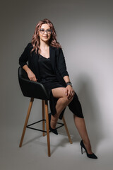 Business woman in glasses in a black dress