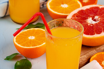 Glass of orange juice with red straw on table