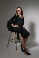 Business woman in glasses in a black dress