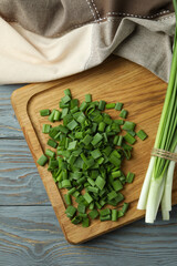 Fresh green onion on cutting board, on gray wooden table