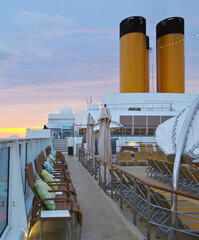Luxury sun loungers and deck lounge chairs on outside terrace, patio or balcony sun pool deck of...
