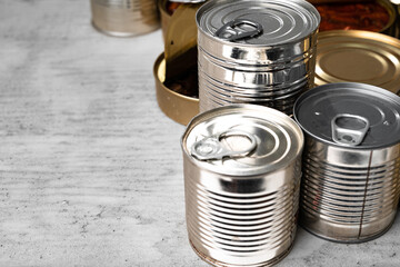 Tin cans with conserved food on gray surface