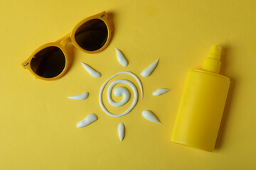 Summer concept with sunscreen on yellow background