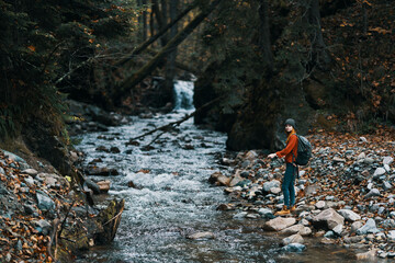 traveler with backpack landscape mountains transparent river pond and forest in the background