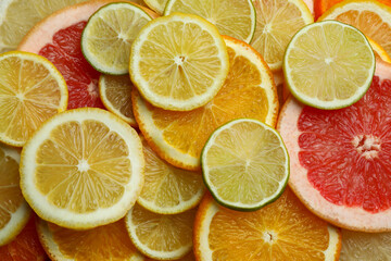 Fototapeta na wymiar Different citrus fresh slices on whole background