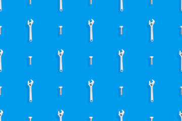 Adjustable metal wrench seamless pattern. Background from a metal wrench and a bolt. 