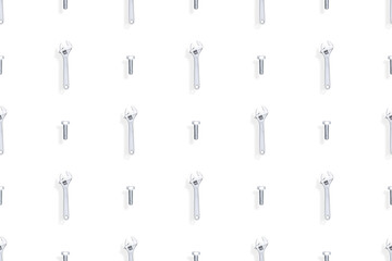 Adjustable metal wrench seamless pattern. Background from a metal wrench and a bolt. 