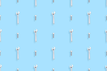 Adjustable metal wrench seamless pattern. Background from a metal wrench and a bolt. 