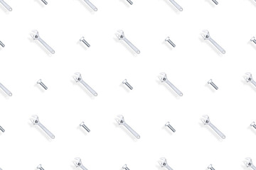 Adjustable metal wrench seamless pattern. Background from a metal wrench and a bolt. 