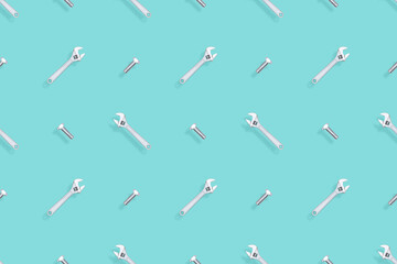 Adjustable metal wrench seamless pattern. Background from a metal wrench and a bolt. 