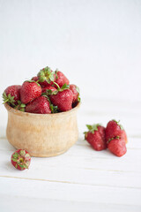 Harvest. Fresh strawberries in the basket on the light rustic background. Organic berries. Space for text