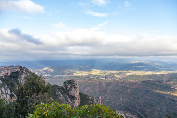 Breathtaking view of the Montserrat mountain range on a sunny spring day near Barcelona, Catalonia, Spain. Colorful mountain landscape. The shadow of the clouds falls to the ground.