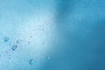 Abstract blue background with raindrops and beautiful bokeh. The concept of autumn and the cold stormy weather. Texture of macro drops on the blurred background of the window. Loneliness sadness