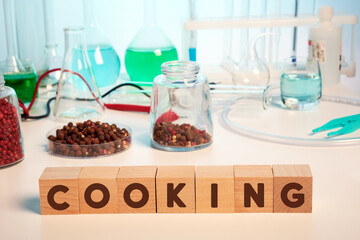 Pepper chemical analysis and cooking text on wooden cubes in lab. Photo of pepper in petri glass dish taken in testing laboratory. Concept of food safety investigation. Different flasks, tubes