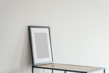 Blank wooden photo frame stands in the interior on a white background. Mockup poster frame.