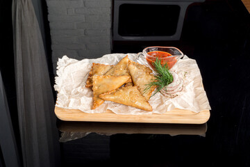 Mini pasties on a wooden board with paper