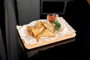 Mini pasties on a wooden board with paper
