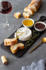 Camembert cheese with toasts, honey and jam. Wine snack.
