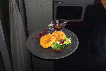 Suluguni cheese with sauce and fresh herbs on slate